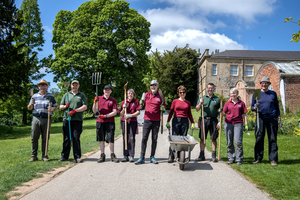 Cannon Hall volunteers walking down path carrying tools for volunteer session